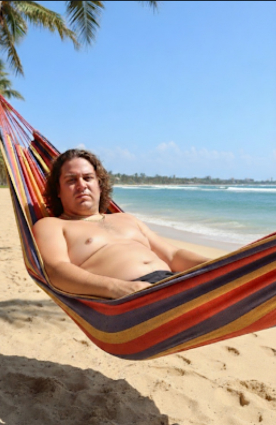 Paul in the before era, reclining in a beach hammock